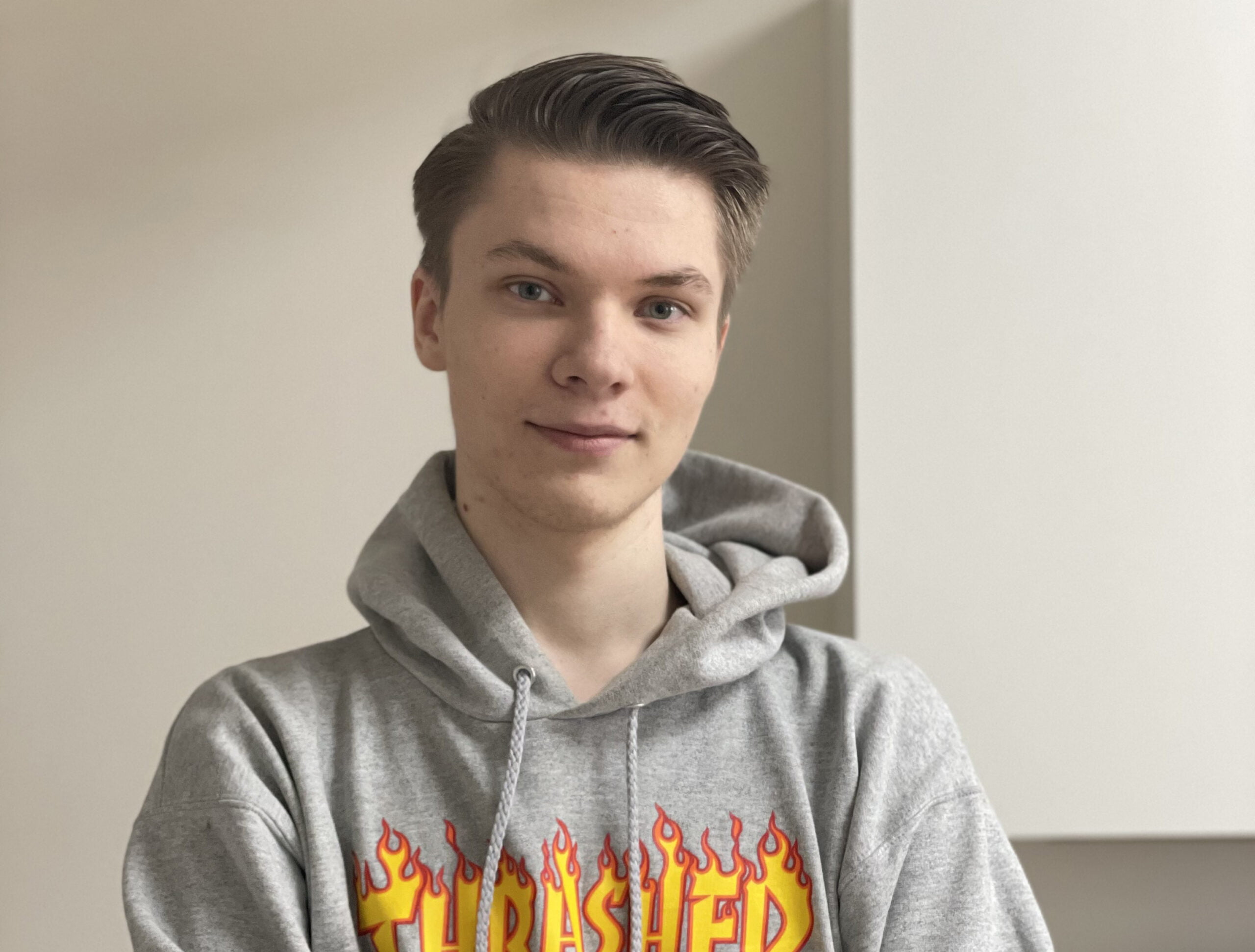 Kille med grå hoodie kollar in i kameran.