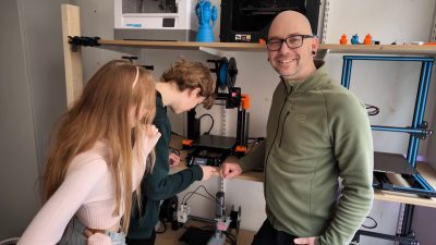 Magnus Rydell står med två elever i makerspace.