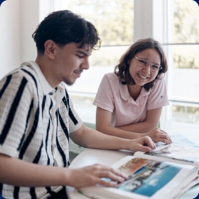 Glada elever som bläddrar tillsammans i en bok.