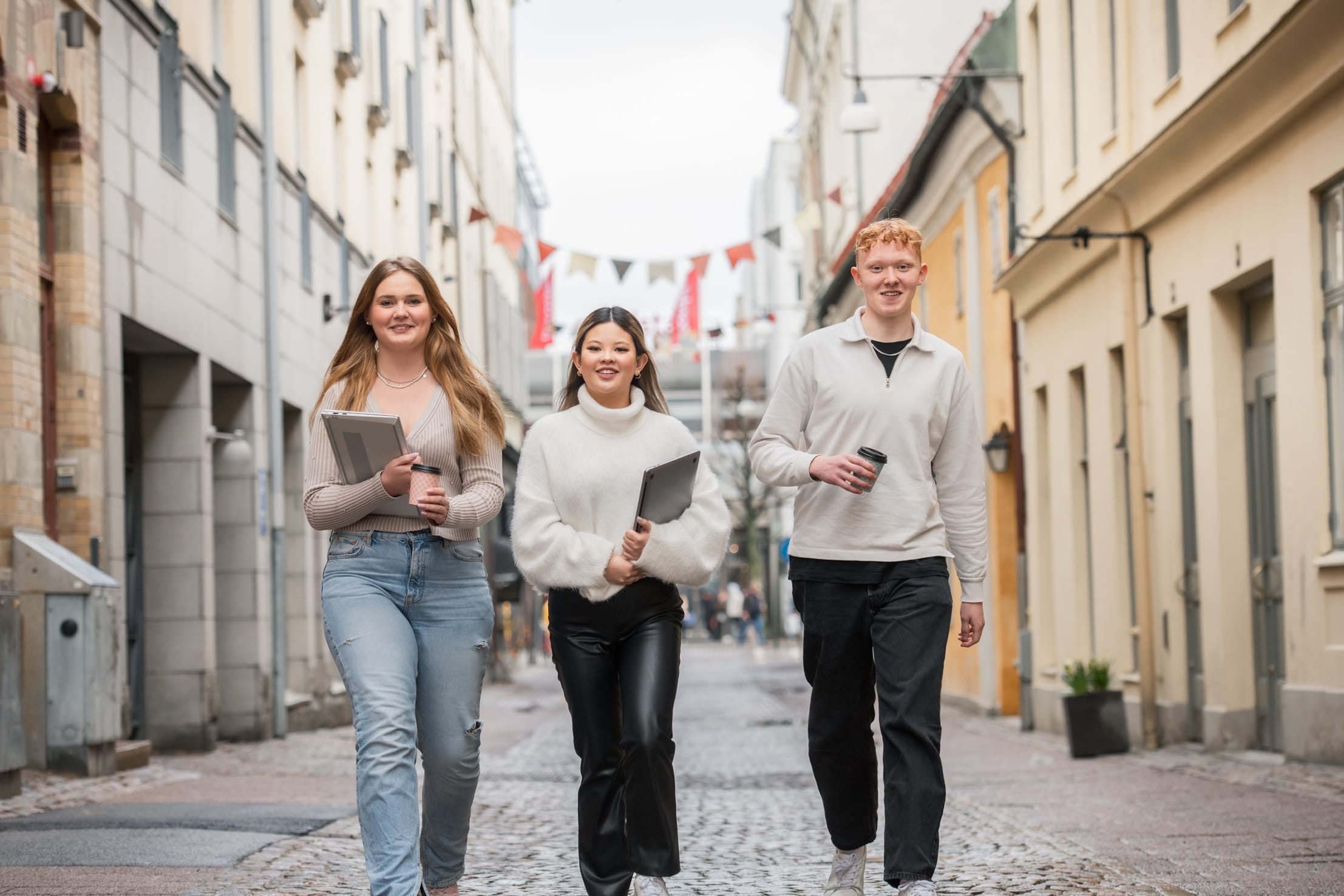 Elever som går tillsammans på gatan och är glada.