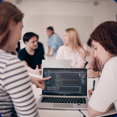 Elever som programmerar och diskuterar med varandra.