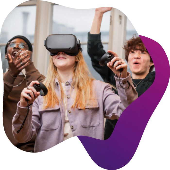 Tre elever står och spelar med VR-utrustning på NTI Gymnasiet