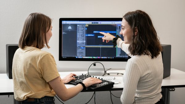 Två elever på musikprogrammet på NTI gymnasiet mixar en låt på datorn