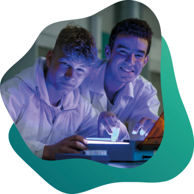 Två glada elever arbetar i labbsalen tillsammans.