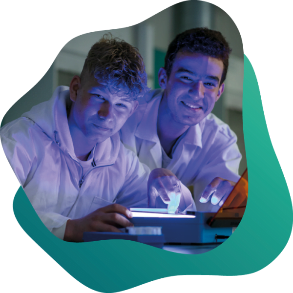 Två glada elever arbetar i labbsalen tillsammans.