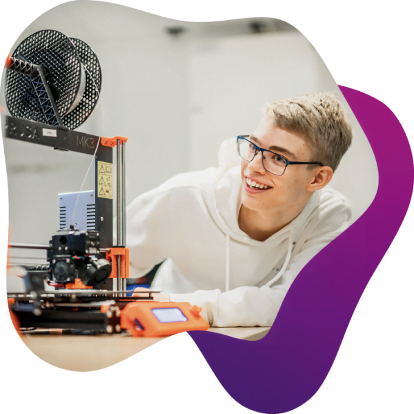 En elev sitter nära en 3D-skrivare och studerar den när den printar ut ett objekt