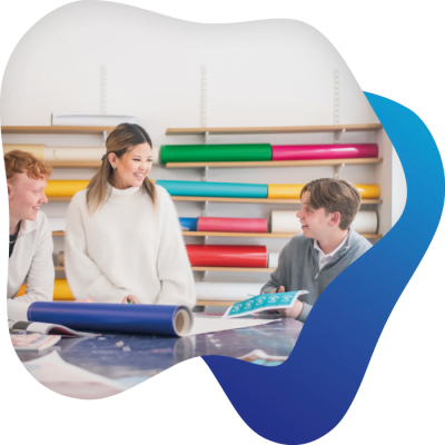 Tre elever interagerar i ett klassrum.