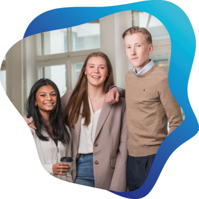 Tre glada elever står i ett klassrum.