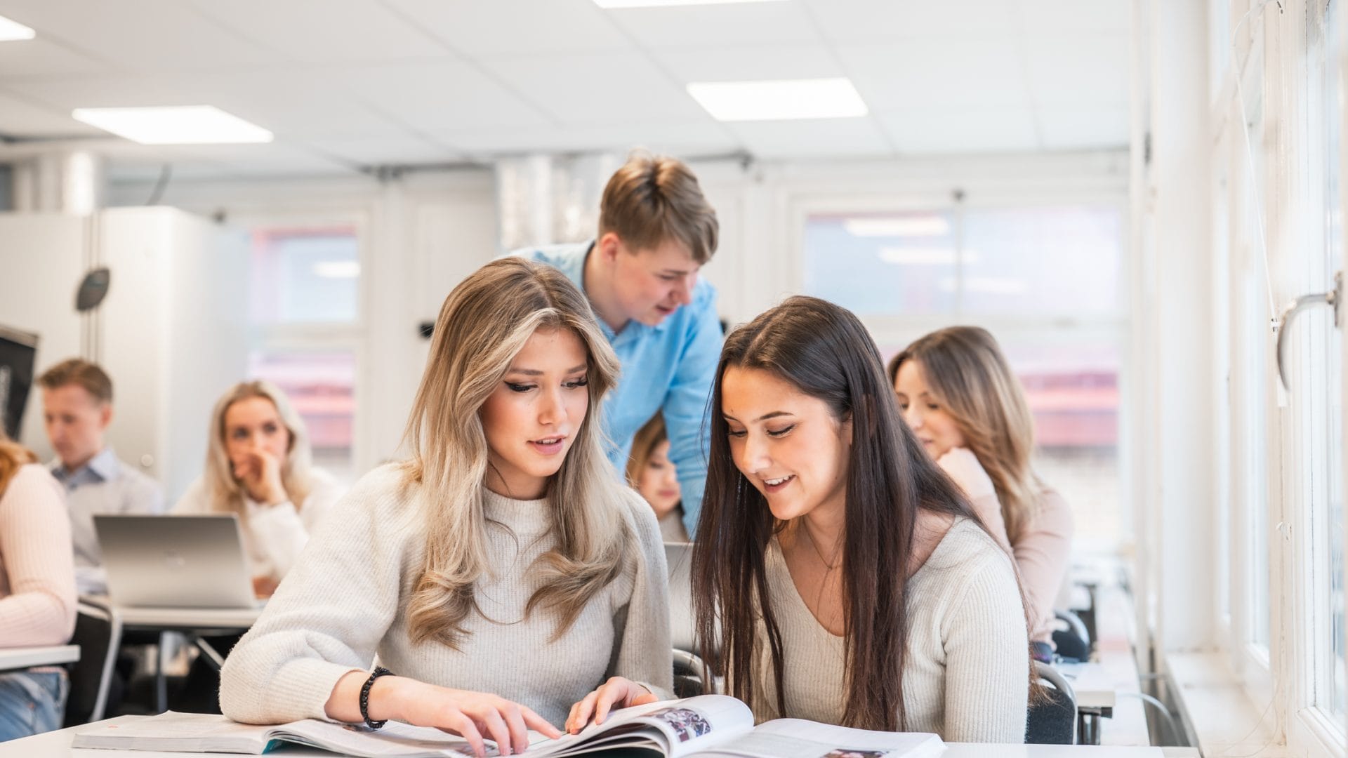 Elever läser ur en bok tillsammans i ett klassrum.