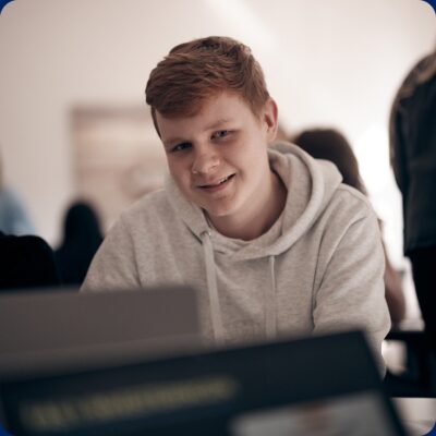 En glad elev i klassrummet som tittar in i kameran.