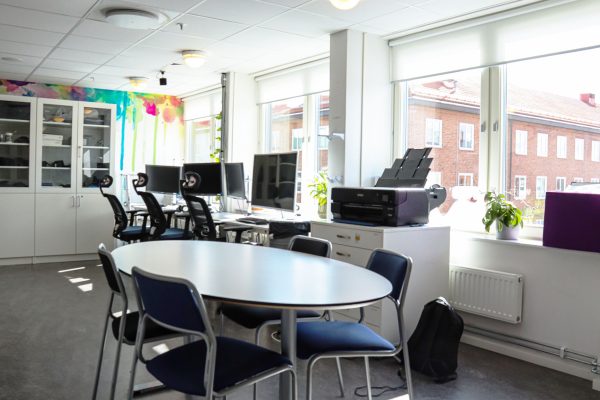 Klassrum med bord och stolar.