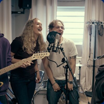 Två elever som sjunger tillsammans i skolans musikstudio.