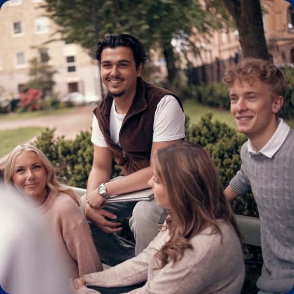 Glada elever som umgås i parken vid skolan.