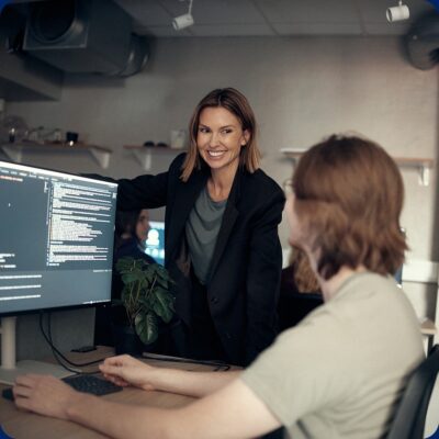 En lärare som tittar på när en elev programmerar.