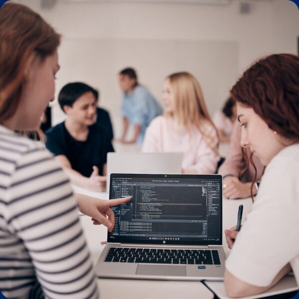 Elever som programmerar och diskuterar med varandra.